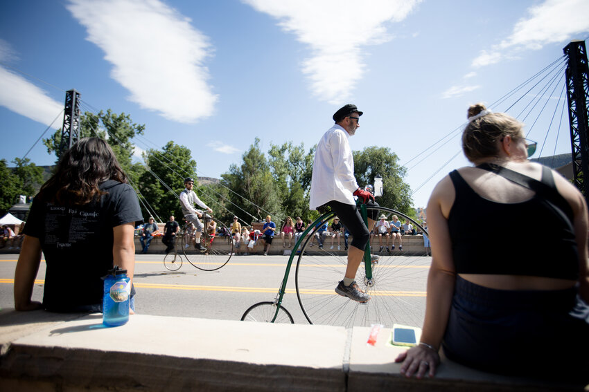 People ride penny farthings in the Buffalo Bill Days parade Saturday morning.